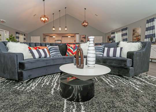 A modern clubhouse with a grey sofa and a round coffee table at Orleans Square in Shreveport, LA