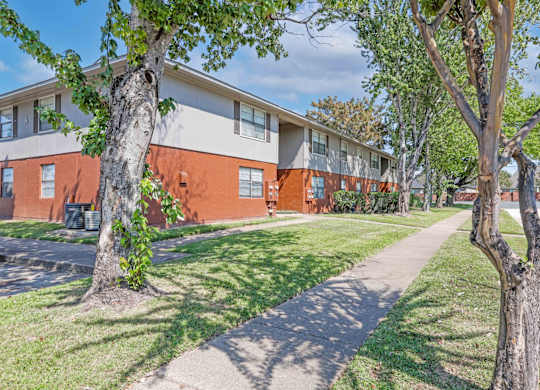 Well-kept landscaping in front of apartment buildings at Orleans Square in Shreveport, LA