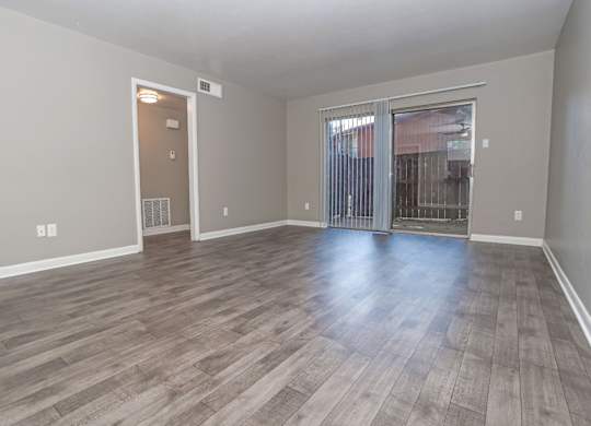 A room with wooden flooring and a sliding glass door at Orleans Square in Shreveport, LA