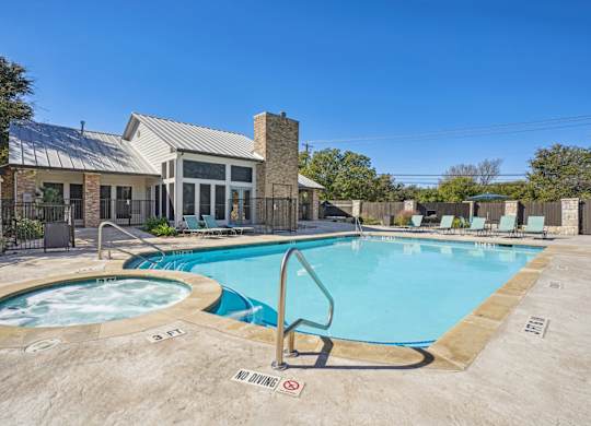 Our resort-style pool with a hot tub behind the leasing office at On the Green apartments in Austin, TX