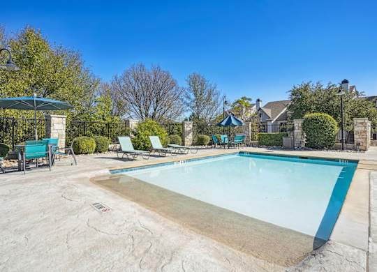 Kiddie pool with lounge chairs at On the Green apartments in Austin, TX