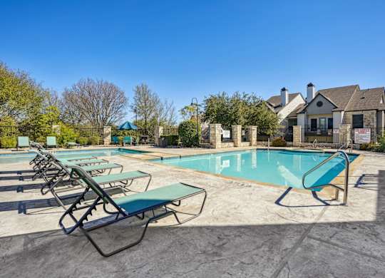 Shot of our pool with lounge chairs at On the Green apartments in Austin, TX