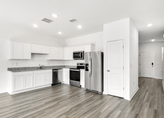 a kitchen with white cabinets and stainless steel appliances