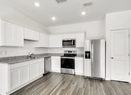 a kitchen with white cabinets and stainless steel appliances