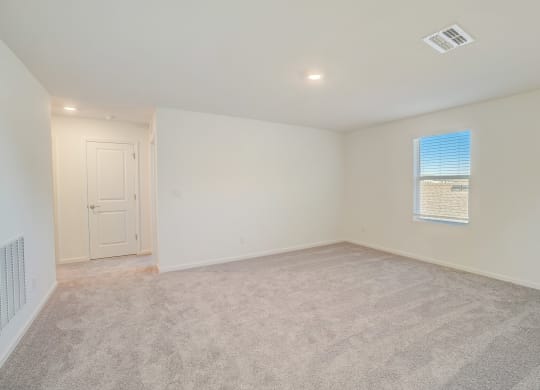 an empty living room with white walls and a window