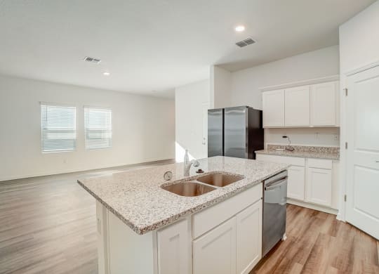 an empty kitchen with white cabinets and a counter top
