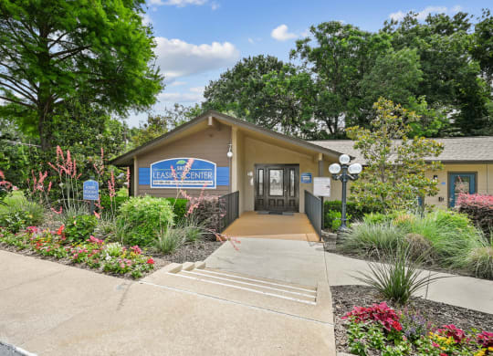 A leasing office with a sign in front of it at Preston Oaks Apartments in Dallas, TX.