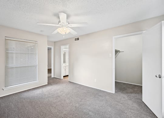 a bedroom with a ceiling fan and closet
