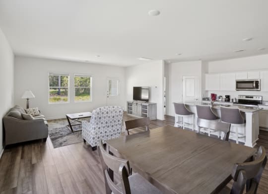 a living room with a dining room table and a kitchen