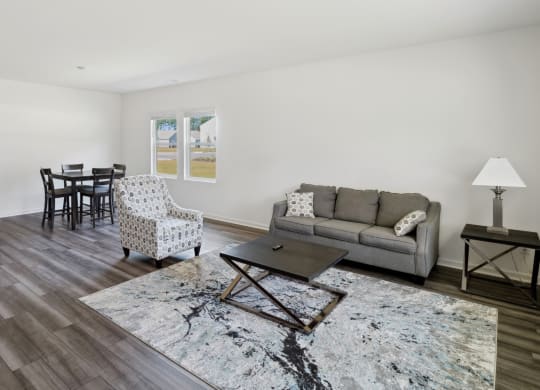 a living room with a couch and chairs and a dining room table