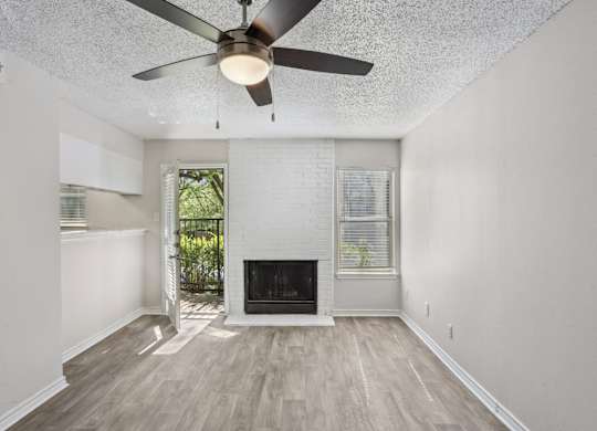 A room with a fireplace and a ceiling fan.