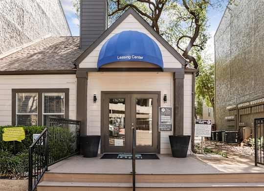 A small building with a blue awning that says Leasing Center.
