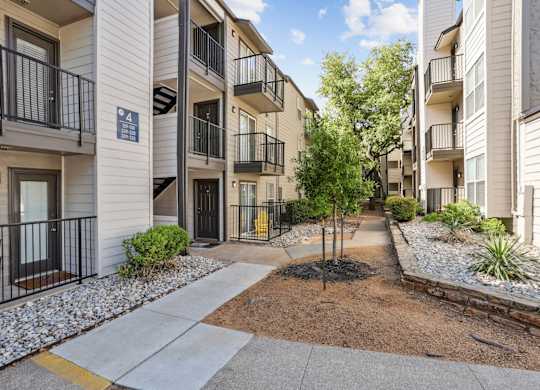 Apartment complex with a tree in the middle of the courtyard.