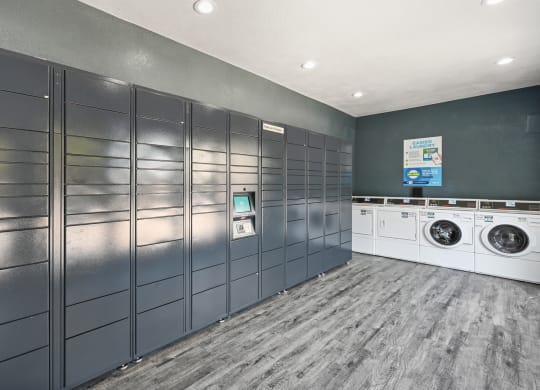 a laundry room with gray lockers and white washers and dryers