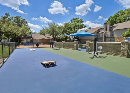 a dog park with a trampoline and agility course at the whispering winds apartments in pear