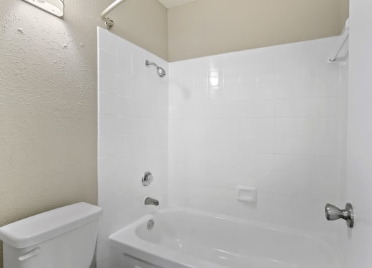 a bathroom with a white tub and a white toilet