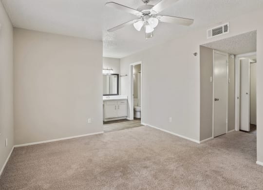 an empty bedroom with a ceiling fan