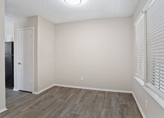a bedroom with hardwood floors and a large window