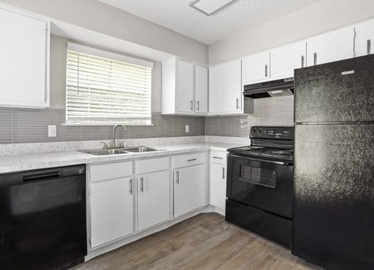 a kitchen with white cabinets and black appliances