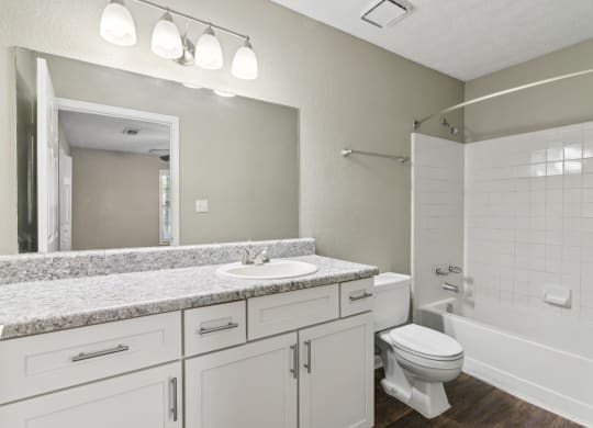 Modern bathroom with a sink, toilet and a shower and ample cabinet space at Oakley Run apartments in Smyrna, GA