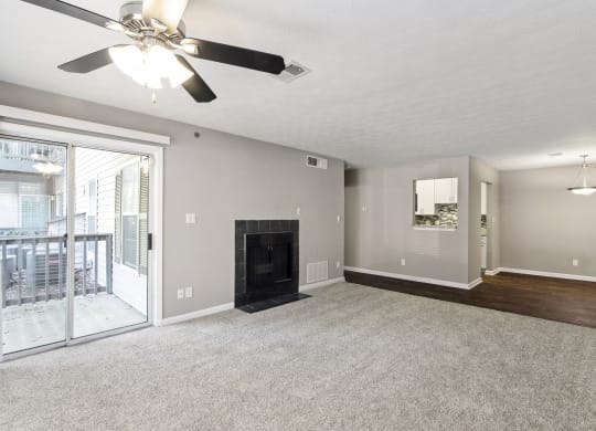 Unfurnished living room with a fireplace and a ceiling fan at Oakley Run apartments in Smyrna, GA