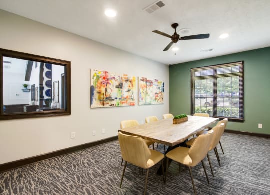 a conference room with a table and chairs and a ceiling fan at Grand Reserve at Columbus Apartments in Columbus, Georgia, GA