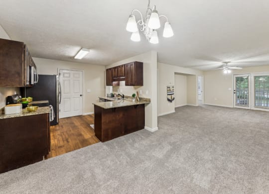 an open living room and kitchen with a carpeted floor  at Grand Reserve Columbus in Columbus, GA