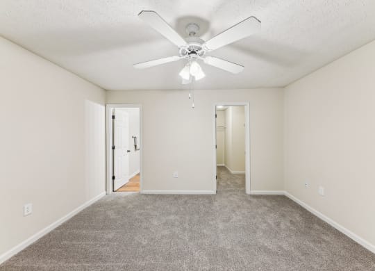 a large bedroom with ceiling fan and carpeted floor  at Grand Reserve Columbus in Columbus, GA