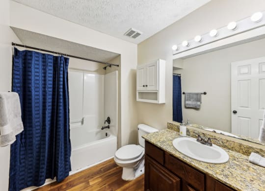 a bathroom with a tub and hardwood floor at Grand Reserve Columbus in Columbus, GA