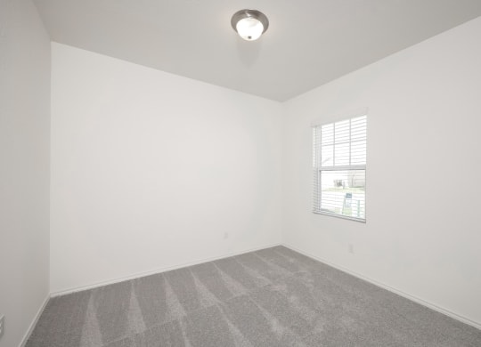 a bedroom with white walls and a window at Beacon at Meridian, San Antonio Texas