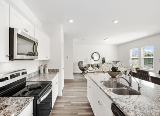 a kitchen with white cabinets and granite countertops