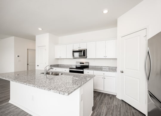 a kitchen with white cabinets and a granite counter top at Beacon at Meridian, San Antonio, 78245