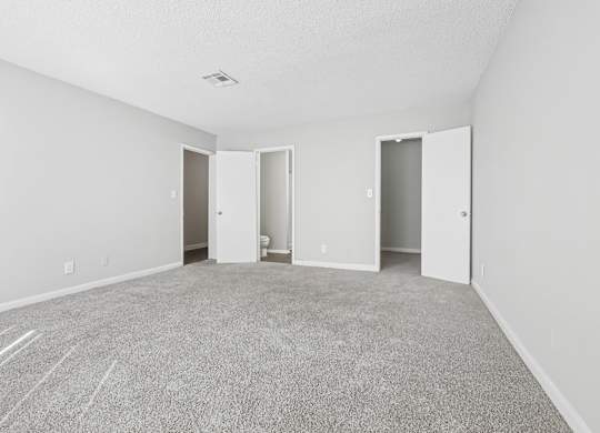 Our spacious master bedroom with carpeted floor and en suite bathroom in C2b floor plan at Riverwood Crossing apartments in Roswell, GA.