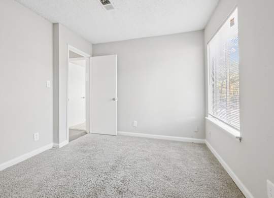 Third bedroom view of entrance with carpet flooring in C2b floor plan at Riverwood Crossing apartments in Roswell, GA.
