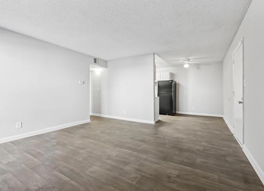 Living room shot looking toward kitchen and dining area with vinyl wood flooring in B1 floor plan at Riverwood Crossing apartments in Roswell, GA.