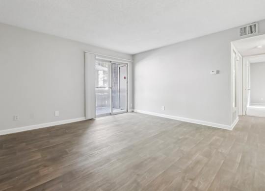 Living room with vinyl wood flooring and a sliding door in the B1 floor plan at Riverwood Crossing apartments in Roswell, GA..