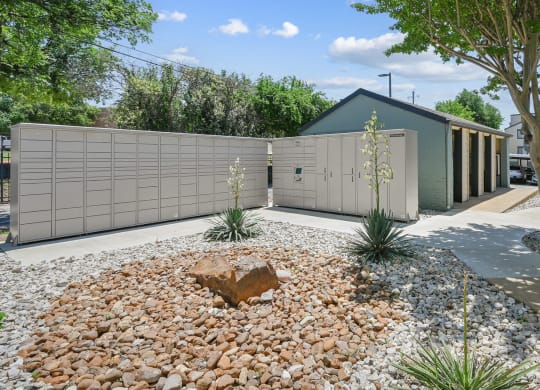 a house with a fence and a rock garden in front of it
