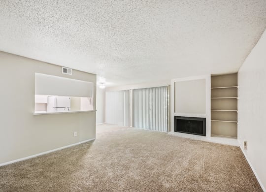 a spacious living room with carpeted flooring and a fireplace