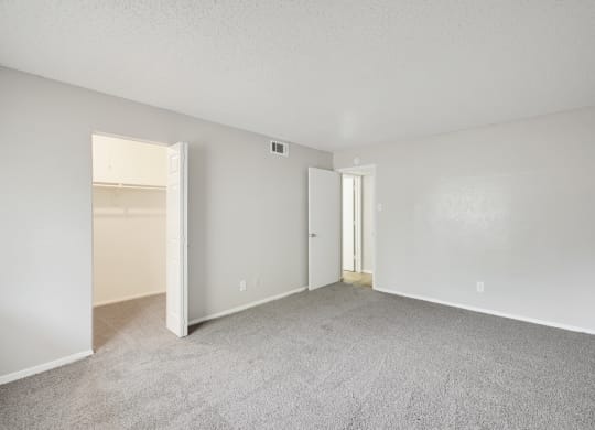a bedroom with a carpeted floor and an open door to a closet