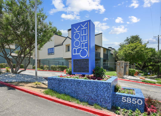 a blue sign with white letters in front of a building