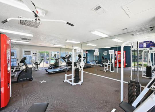a spacious fitness center with cardio machines and other exercise equipment