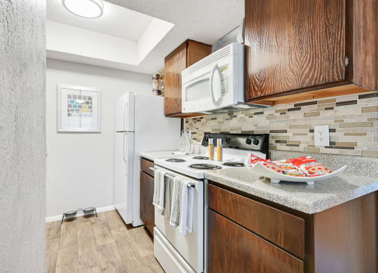 a kitchen with a white refrigerator freezer next to a stove top oven