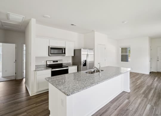 a kitchen with white cabinets and a granite counter top