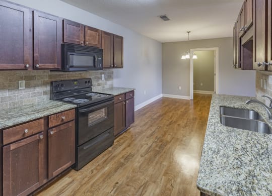 a kitchen with wood cabinets and granite counter tops and black appliances