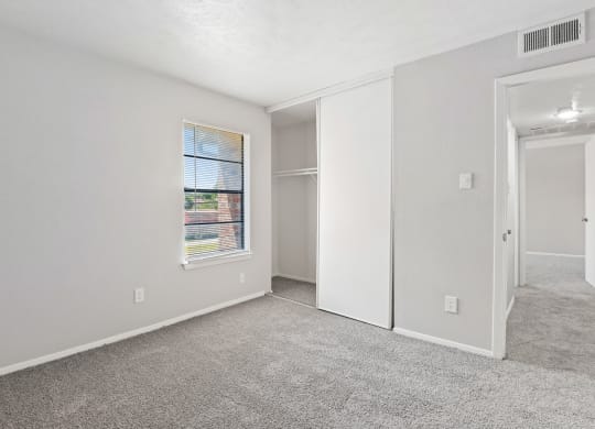 a bedroom with white walls and carpet
