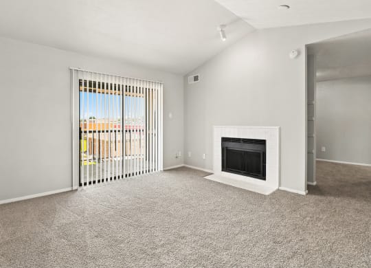 a living room with a fireplace and a door leading to a balcony