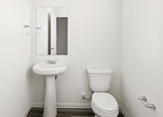 a bathroom with a toilet sink and mirror at Beacon at Bunton Creek, Kyle Texas