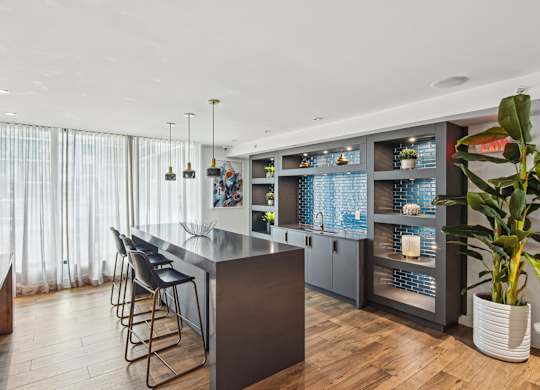 Community kitchen with island and shelving at Twenty2 West luxury apartments in Miami, FL