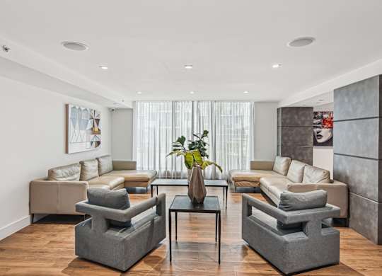 Resident lounge area with grey and beige furniture at Twenty2 West luxury apartments in Miami, FL