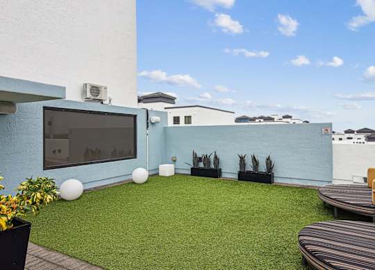 Sundeck with a television and seating at Twenty2 West luxury apartments in Miami, FL